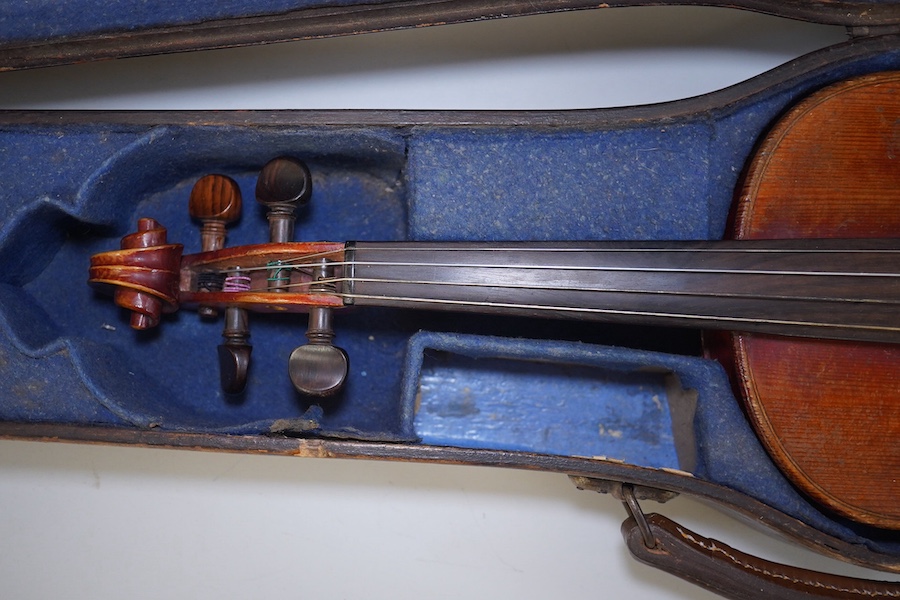 A late 19th century violin, bears fake Stradivarius label, cased, back measures 36cm. Condition - fair